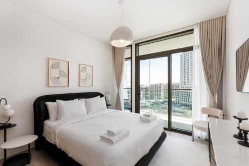 a bedroom with a bed and a large window at Palace Residence, Dubai Creek Harbour - Mint Stay in Dubai