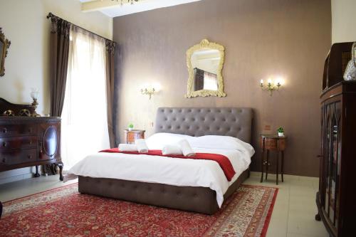a bedroom with a large bed and a mirror at Cottonera Lines Boutique Holiday Accomodation in Cospicua