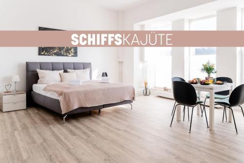 a bedroom with a bed and a table and chairs at Schiffskajüte in Flensburg