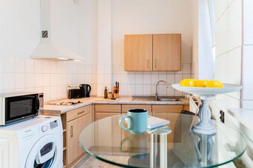 a kitchen with a glass table and a dishwasher at Schiffskajüte in Flensburg