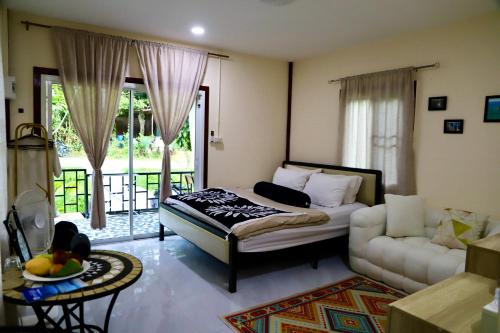 a living room with a bed and a couch at Tiny Boutique House Koh Kood in Ban Lak Uan