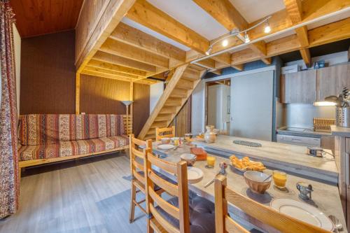 une salle à manger avec une table et un canapé dans l'établissement Les Balcons de la Sagne - Au Pied des Pistes, à Huez