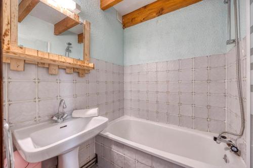 a bathroom with a sink and a bath tub at Les Balcons de la Sagne - Au Pied des Pistes in LʼHuez