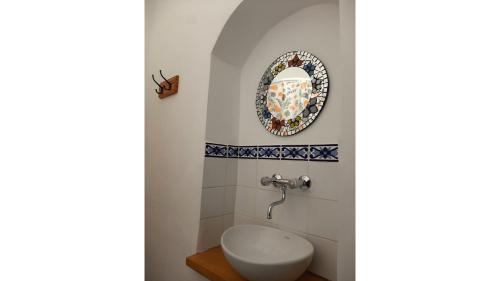 a bathroom with a toilet and a plate on the wall at La Vieja Esquina in Cachí