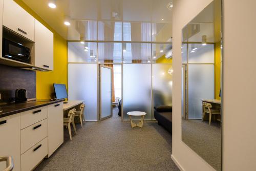 uma cozinha com paredes amarelas e uma sala de estar em Partner Guest House Klovs'kyi em Kiev