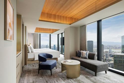 a hotel room with a bed and a couch and a chair at THE OSAKA STATION HOTEL, Autograph Collection in Osaka