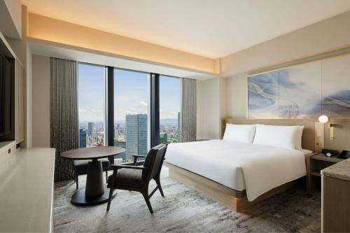 a hotel room with a bed and a desk and a table at THE OSAKA STATION HOTEL, Autograph Collection in Osaka
