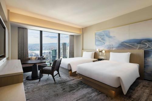 a hotel room with two beds and a desk at THE OSAKA STATION HOTEL, Autograph Collection in Osaka