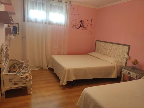 a bedroom with two beds and a window and a chair at Casa da Pinguela Camino Inglés in Ordes