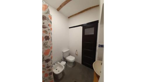 a bathroom with two toilets and a black door at La Vieja Esquina in Cachí