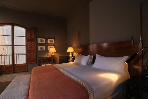 a bedroom with a large bed with white pillows at Can Cera Hotel in Palma de Mallorca