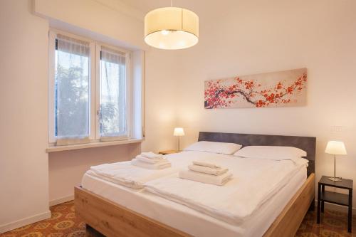 a bedroom with a large bed with white sheets at Villa Cesarina-Vista lago totale in Brenzone sul Garda