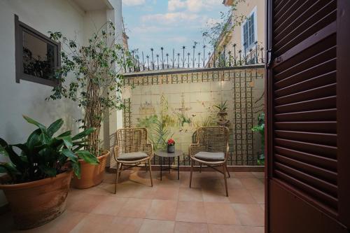 a patio with a table and chairs and plants at Can Cera Hotel in Palma de Mallorca