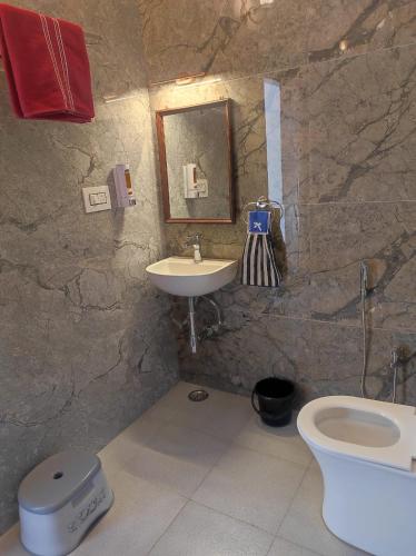 a stone bathroom with a sink and a toilet at Ardas Villa Bikaner - Heritage Luxury Boutique Stay in Bikaner