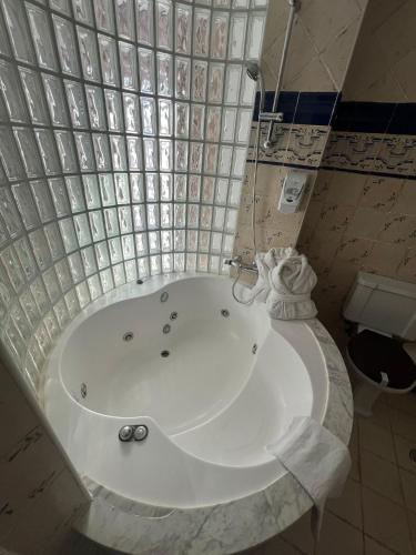 a white tub in a bathroom with a toilet at Posada la Leyenda in Santillana del Mar