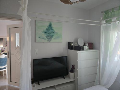 a living room with a flat screen tv next to a window at Apartment sofia sea view in Vrasná