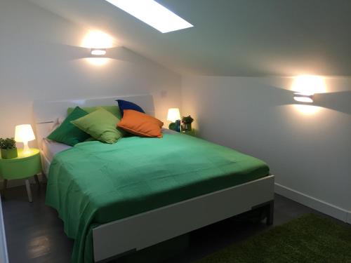 - une chambre avec un lit doté de draps verts et d'oreillers colorés dans l'établissement Neues, modernes Steinchalet mit grosser Terrasse und Pool bei Rondinara, à Bonifacio