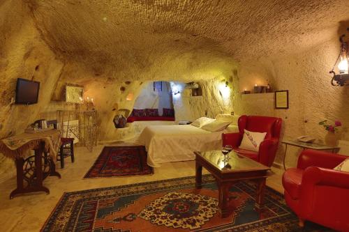 a bedroom with a bed in a cave style room at Jerveni Cave Hotel in Mustafapaşa