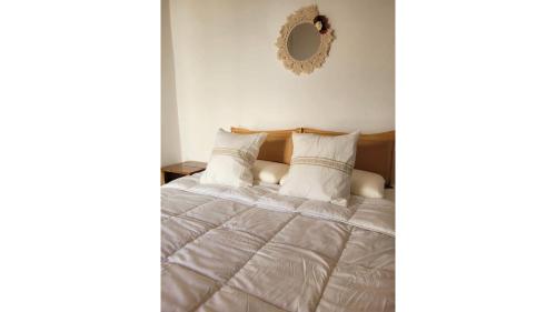 a bedroom with a bed with white sheets and a mirror at La Vieja Esquina in Cachí