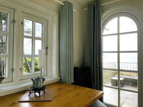 a living room with a table and two windows at Huus Lüttenblick Whg Amrumblick in Südstrand