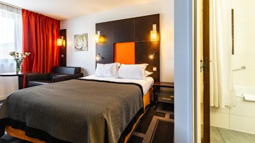 a hotel room with a bed and a bathroom at Holiday Inn Dijon Toison D'or by IHG in Dijon
