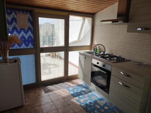 a kitchen with a stove top oven next to a window at Appartamento bel vedere in Pagliara