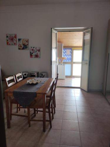 a dining room with a table and chairs and a door at Appartamento bel vedere in Pagliara