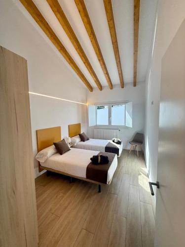 a bedroom with a large bed with a wooden ceiling at Apartamentos el puente in La Abadilla