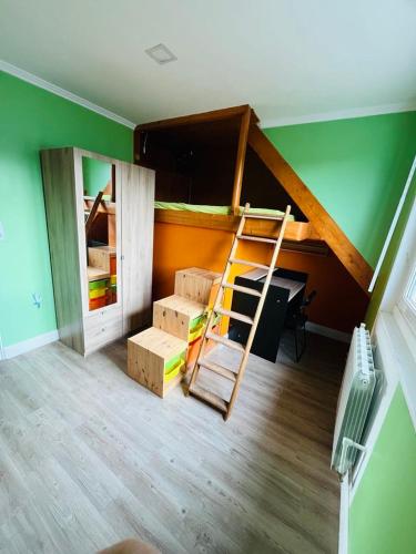 a room with a bunk bed with a ladder and boxes at Charmante maison familiale in Lannion