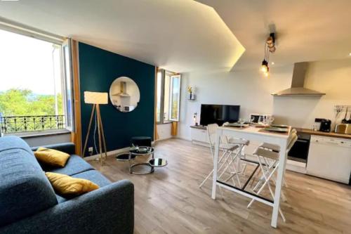 un salon avec un canapé bleu et une cuisine dans l'établissement Scandinavian-style apartment, à Aubenas