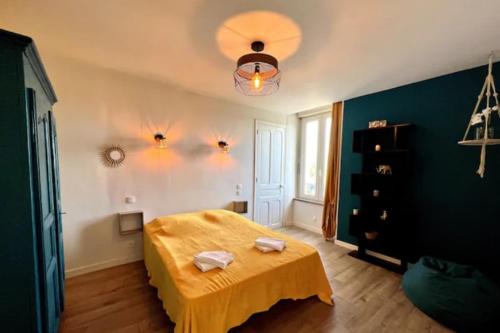 - une chambre avec un lit jaune et 2 serviettes dans l'établissement Scandinavian-style apartment, à Aubenas