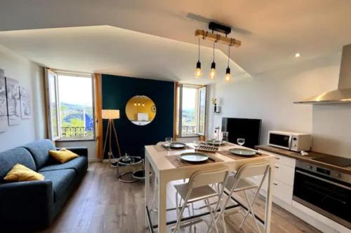 une cuisine et un salon avec un canapé et une table dans l'établissement Scandinavian-style apartment, à Aubenas