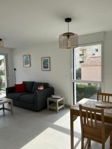un salon avec un canapé et une table dans l'établissement Appartement neuf, climatisé et au calme à Fréjus Plage, à Fréjus