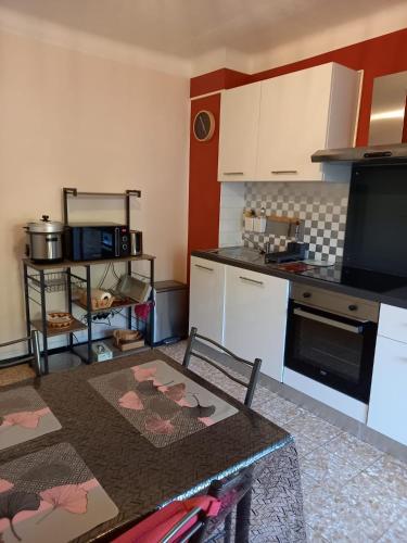 une cuisine avec une table et un comptoir dans l'établissement ISHTa, à Vernet-les-Bains