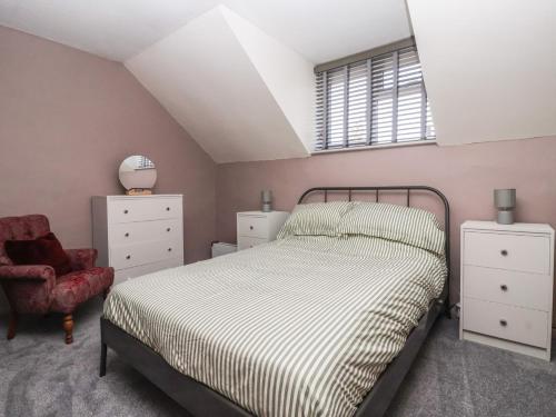 a bedroom with a bed and a chair at Chestnut Cottage in Wetwang