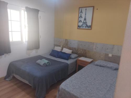 a bedroom with two beds and a tower on the wall at Arguinegin 2 bedroom apartment in Arguineguín