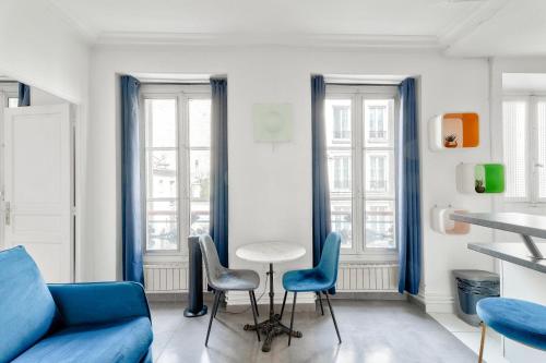 - un salon avec des fauteuils bleus et un canapé bleu dans l'établissement GuestReady - Modern comfort in Les Batignolles, à Paris