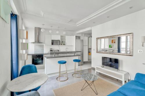 - une cuisine avec une table et des chaises bleues dans l'établissement GuestReady - Modern comfort in Les Batignolles, à Paris