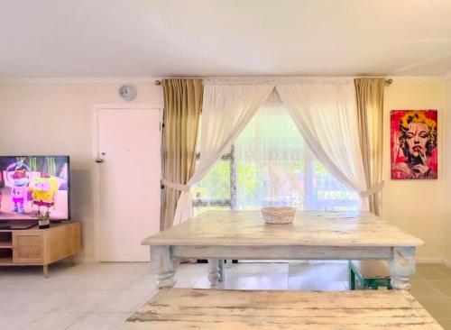a living room with a table and a window at RetroRhapsody in Gold Coast