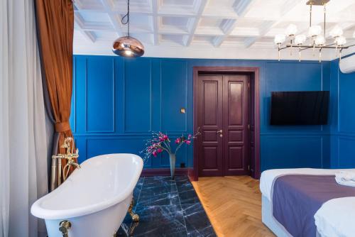 a bathroom with blue walls and a tub and a bed at HIGHLINE DOWNTOWN ApartHotel OLDTOWN UNIRII SQUARE in Bucharest