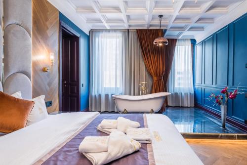 a bedroom with a tub and a bed with towels at HIGHLINE DOWNTOWN ApartHotel OLDTOWN UNIRII SQUARE in Bucharest
