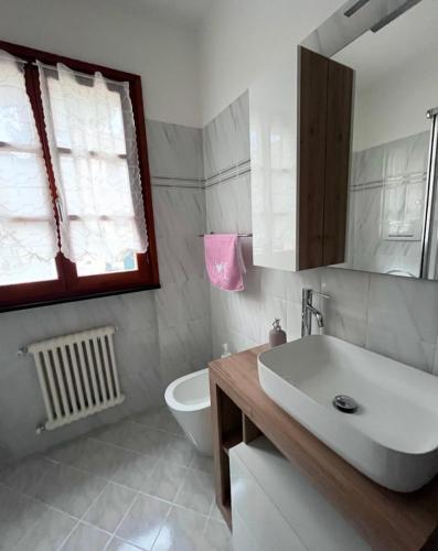 a bathroom with a sink and a toilet and a window at I Portici in Chiavari