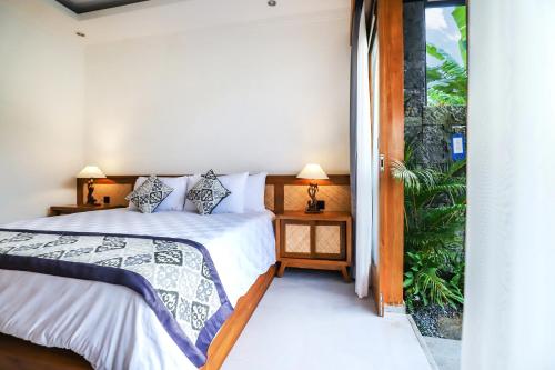 BlahbatuにあるMarvella Villa - Rare Finding near Ubud Centerのベッドルーム1室(ベッド1台付)、バルコニーへのドアが備わります。