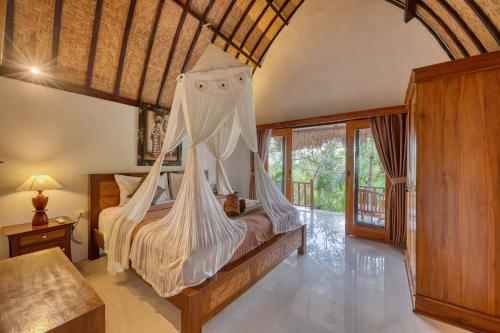 a bedroom with a bed with a mosquito net at Innala Retreat Nusa Penida in Nusa Penida