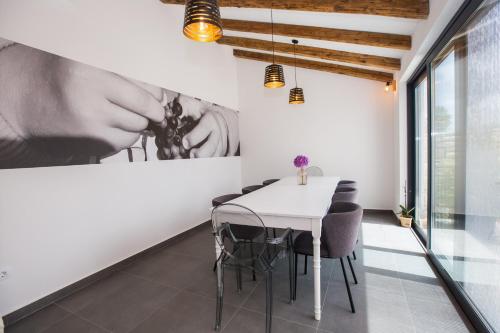 a dining room with a white table and chairs at Villa Tiamo in Labinci