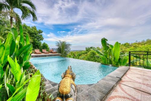 a swimming pool in the middle of a resort with trees at Innala Retreat Nusa Penida in Nusa Penida