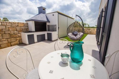 a table with a green vase on top of it at Villa Tiamo in Labinci
