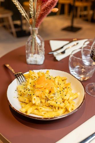 a plate of pasta with a fork on a table at ibis Lille Centre Gares in Lille