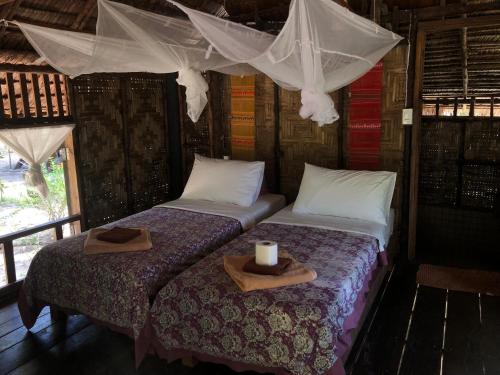two beds with towels and a candle on top of them at Horizon Eco Resort in Ko Phra Thong