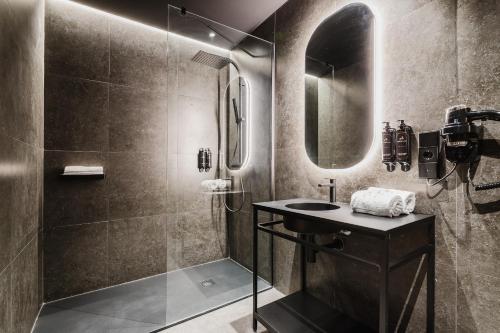 a bathroom with a shower and a sink and a mirror at Hotel Arena Select in Valencia